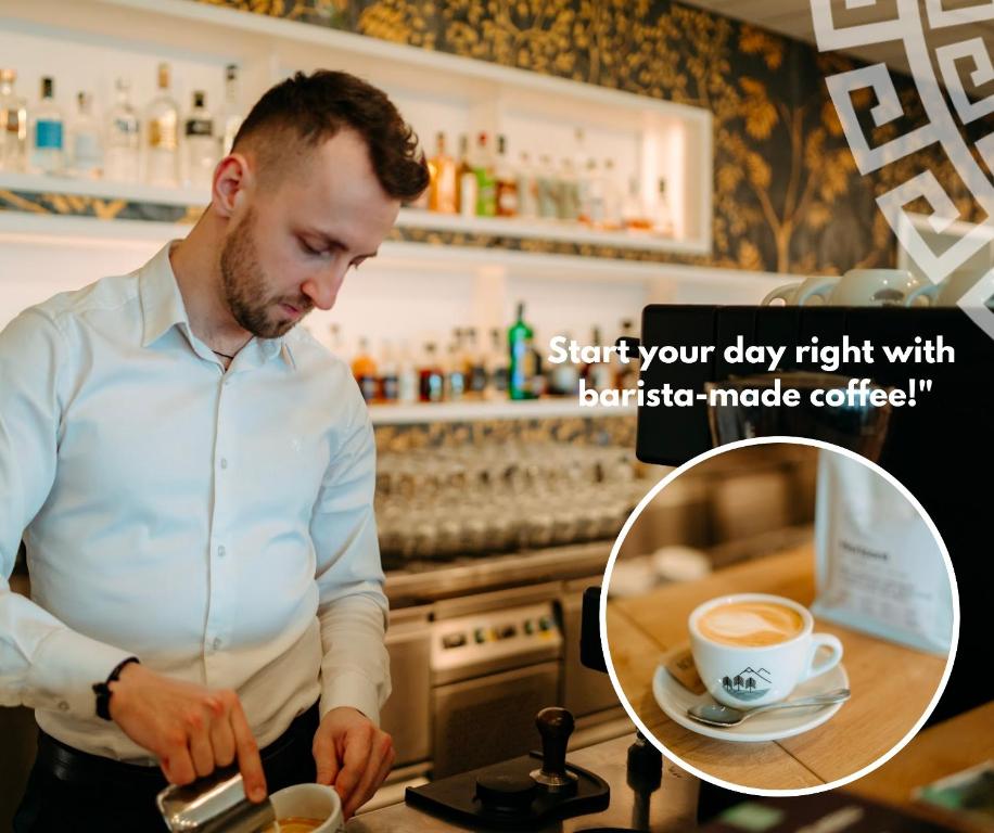 a man preparing a cup of coffee in a kitchen at Hotel Galatea in Mladá Boleslav