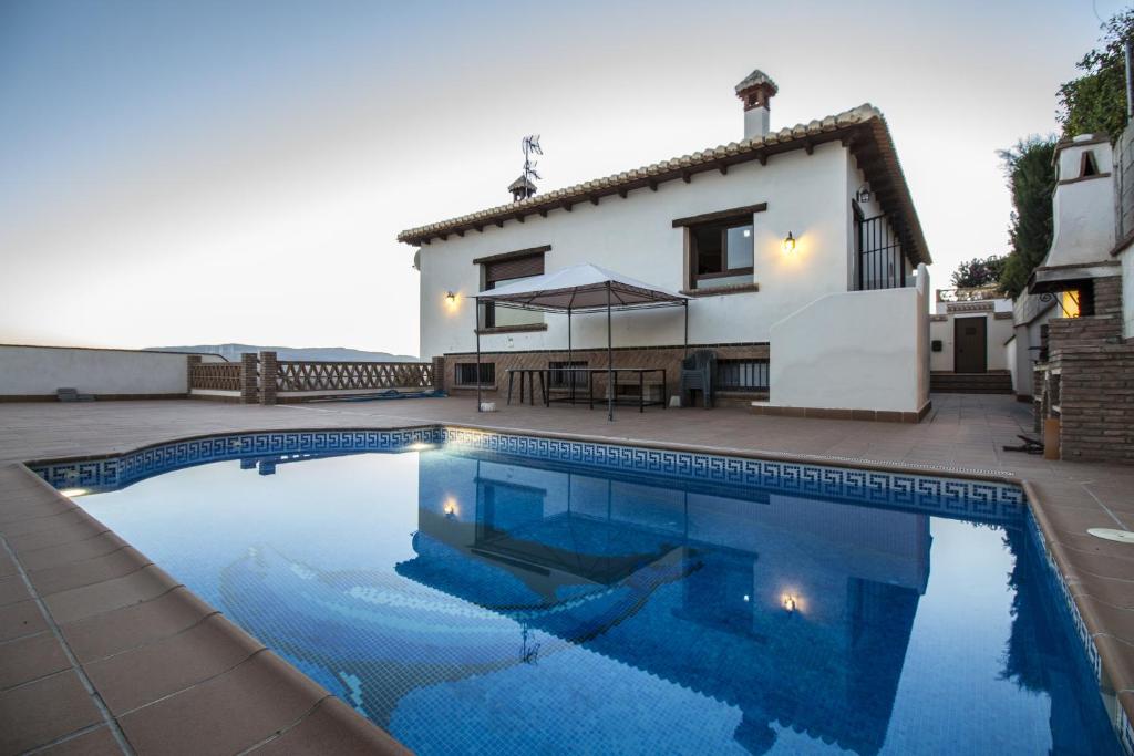 Villa con piscina frente a una casa en Casa Vistas del Valle en Dúrcal