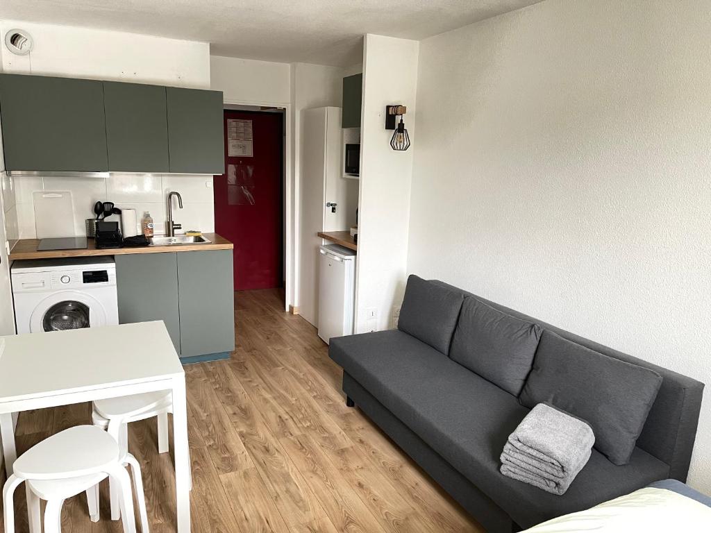 a living room with a couch and a kitchen at T2D Apartment - Suite TVR proche Disneyland Paris in Bussy-Saint-Georges