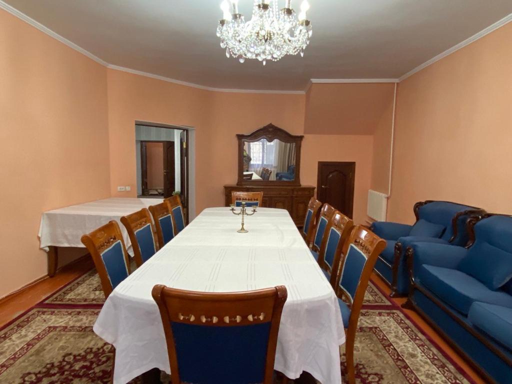uma sala de jantar com uma mesa e um sofá azul em Мини-гостиница АЙ em Shymkent