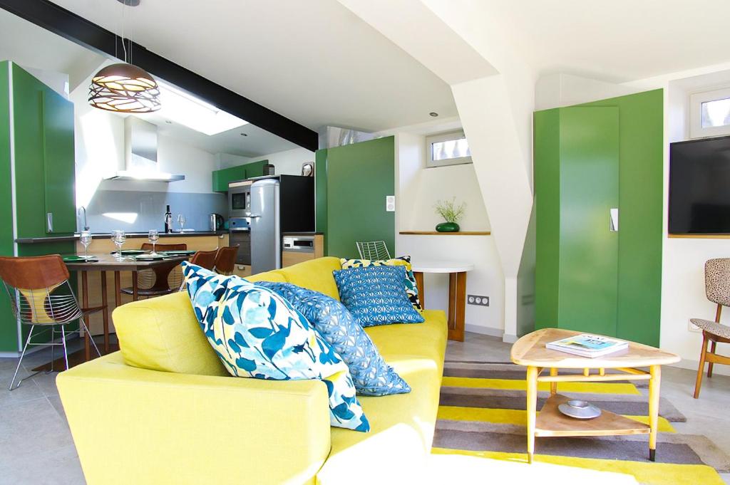 ボルドーにあるChartreuse du Parc - Appartement 2 chambres avec Parking - Caudéranのリビングルーム(黄色のソファ付)、キッチンが備わります。