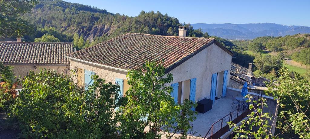 una casa con techo de baldosa en una colina en Les terrasses de la vallée du miel, en Vaumeilh