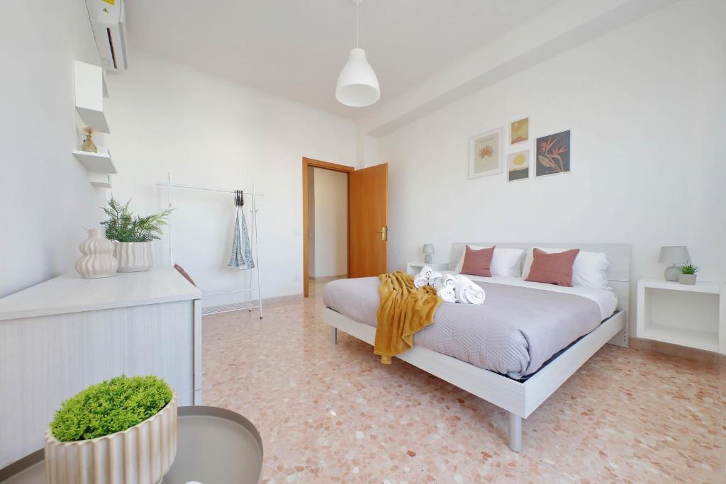 a white bedroom with a bed and a table at Ampio con ottimi collegamenti per Roma & Aeroporto in Fiumicino