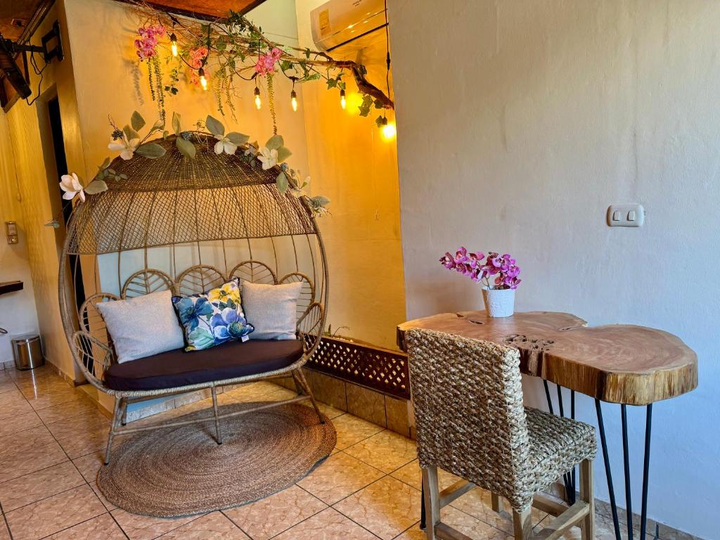Habitación con mesa, silla y jaula para aves. en Orquídea Loft, en Juayúa