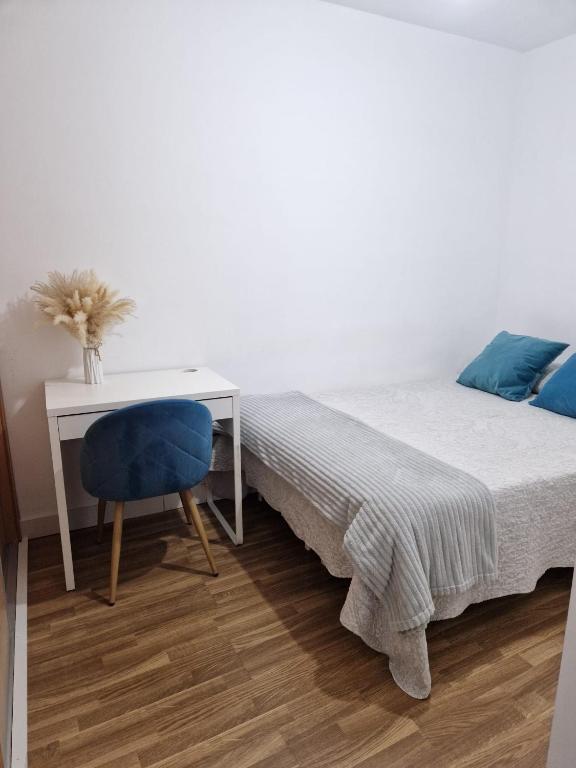 a bedroom with a bed with a desk and a chair at Quarto com banheiro privado em apartamento familiar in Alicante
