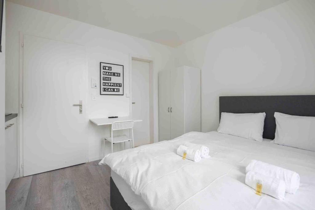 een slaapkamer met een groot wit bed en handdoeken bij Urban Oasis with Queen Bed and View BE-42 in Zürich