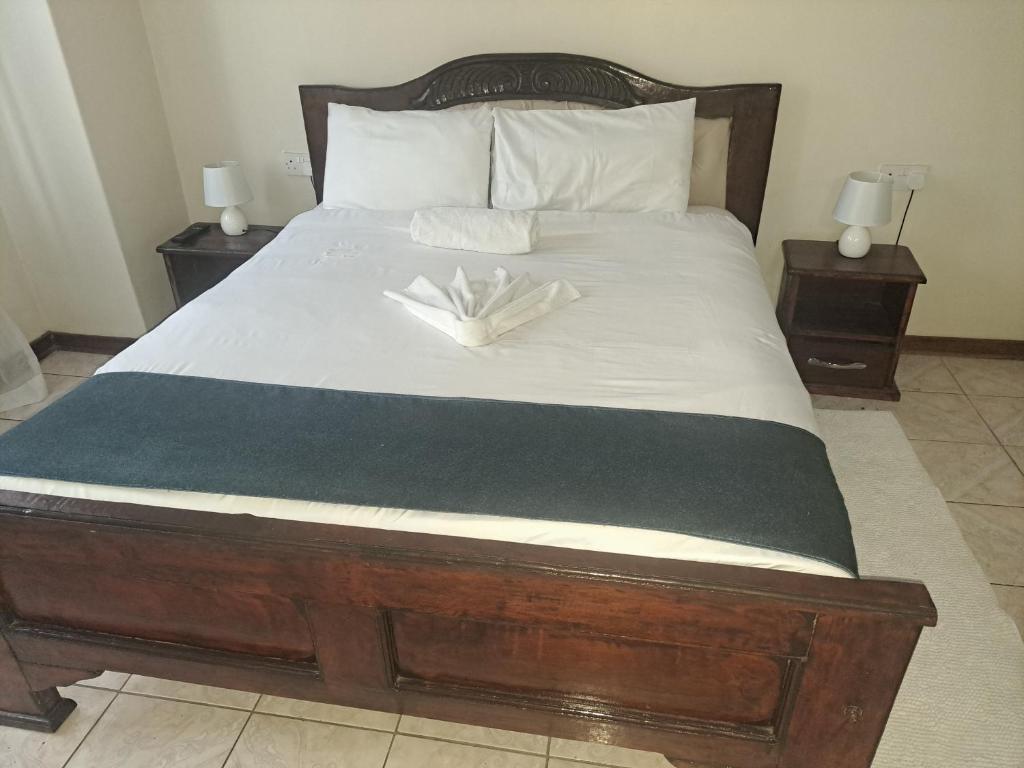 a bed with two white gloves on top of it at LOTUS LODGE in Gaborone