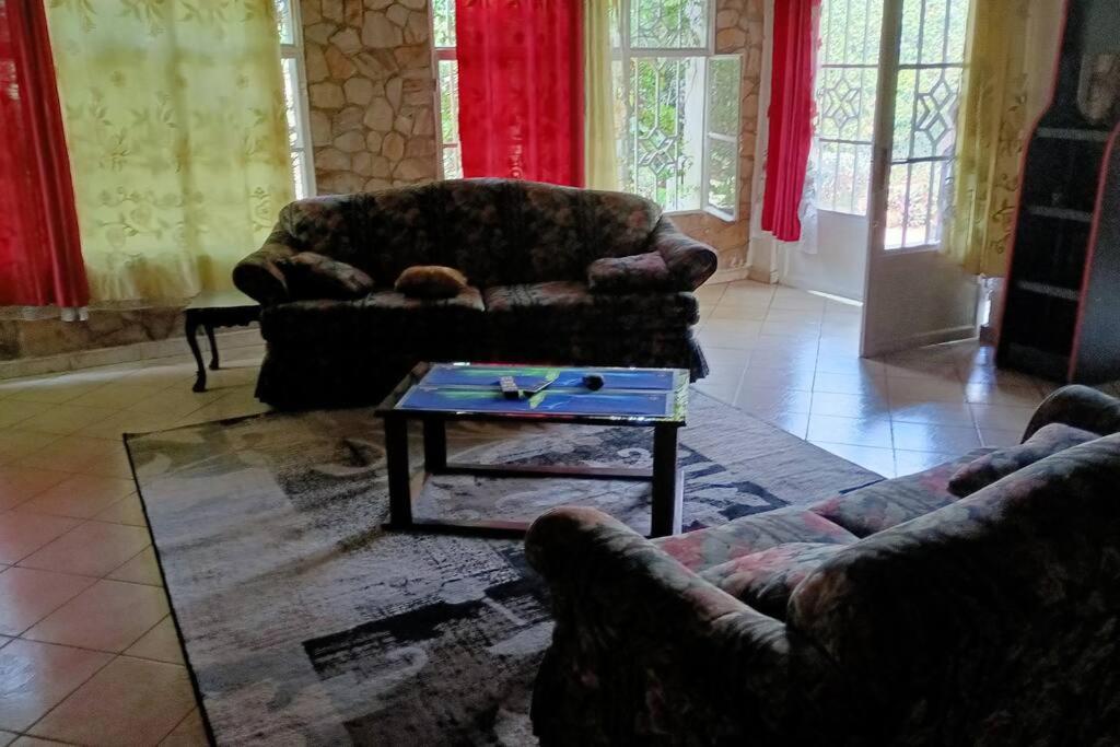 a living room with two couches and a coffee table at COLIBRI VILLA 3 ROOMS in Gisenyi