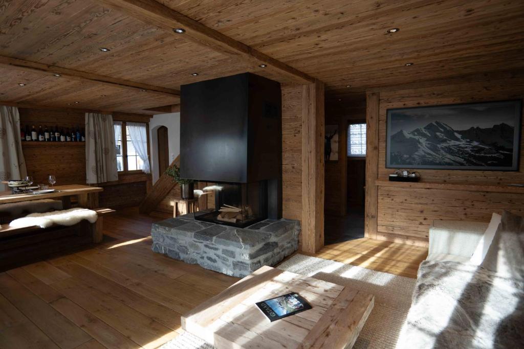 Cabaña con sala de estar con chimenea en Gstaad Living with emotion, en Gsteig