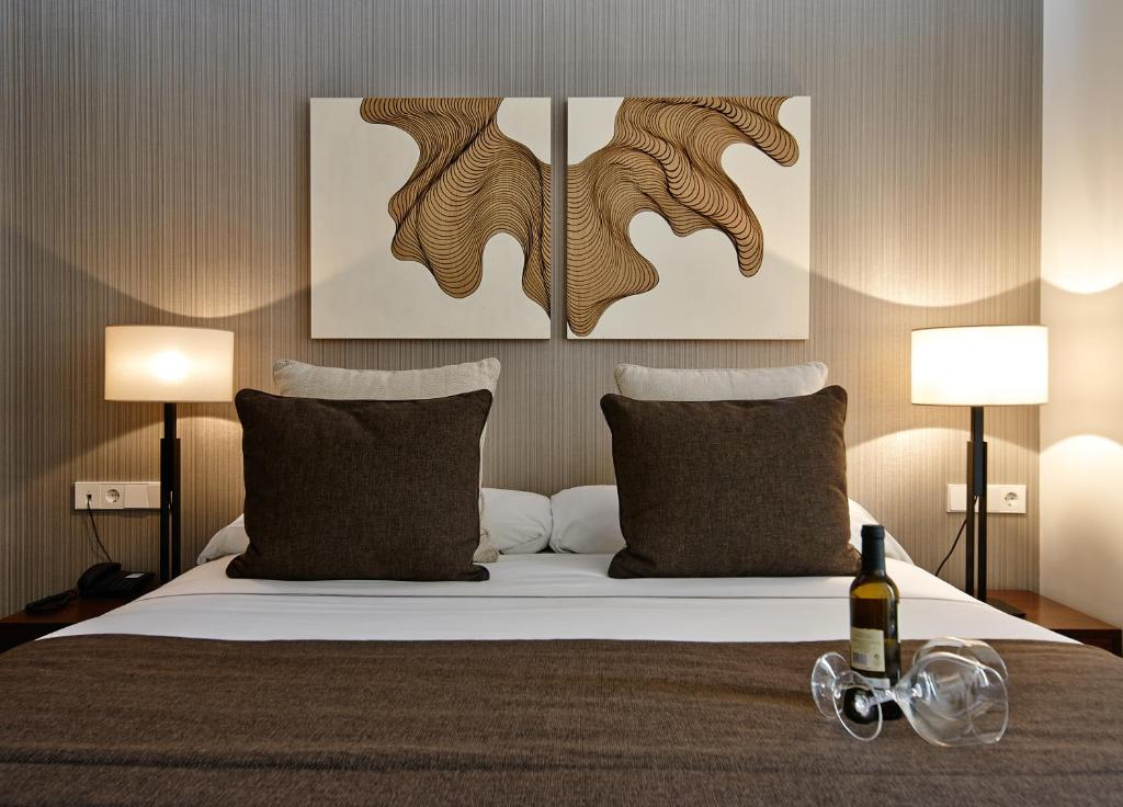 sypialnia z łóżkiem z dwoma obrazami na ścianie w obiekcie Carris Cardenal Quevedo w mieście Ourense