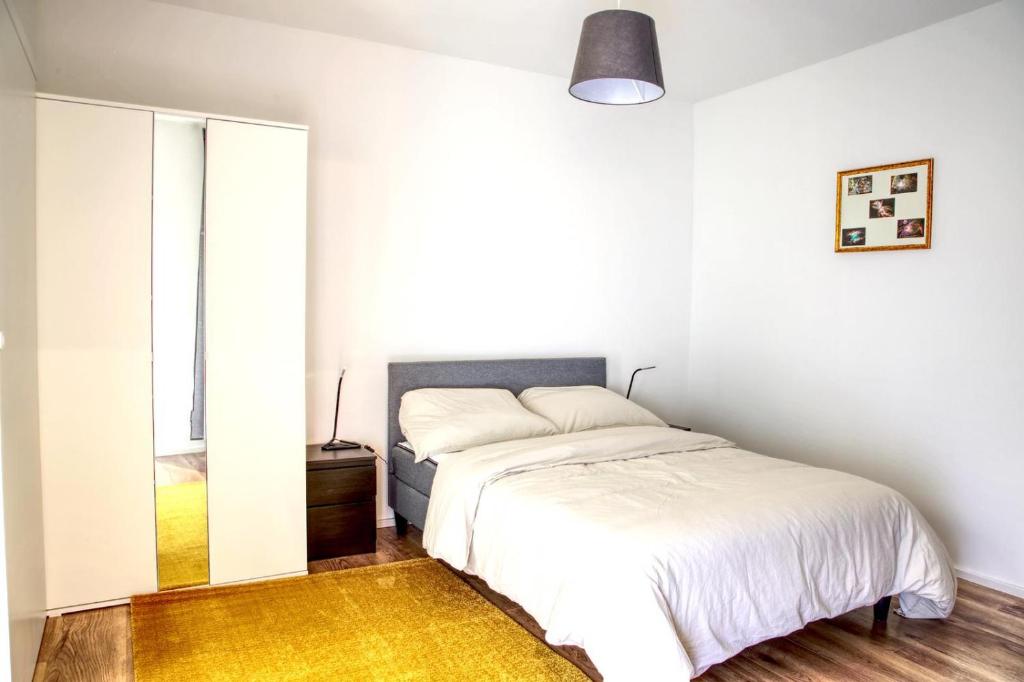 um quarto branco com uma cama e um espelho em Dream home em Essen