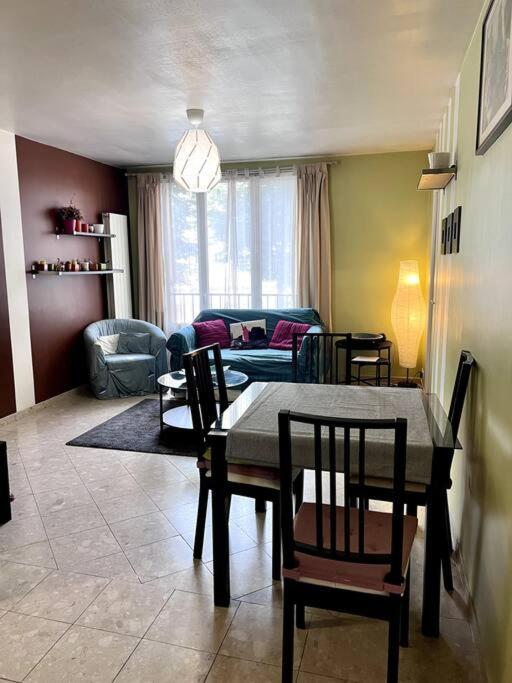 salon ze stołem, krzesłami i kanapą w obiekcie Charmant appartement tout équipé avec 2 chambres w mieście Ivry-sur-Seine