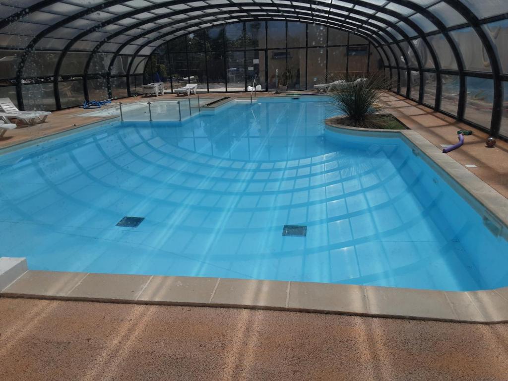a large swimming pool inside of a building at Riva Bella chez Caraphou in Ouistreham