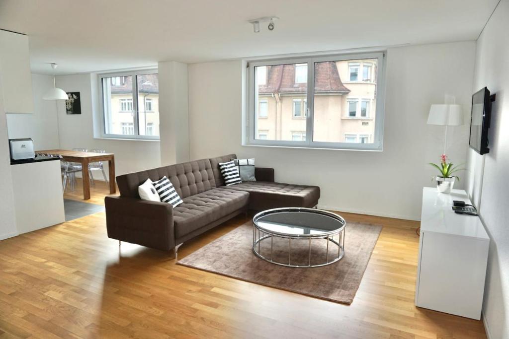 ein Wohnzimmer mit einem Sofa und einem Tisch in der Unterkunft Balcony Suite in Central Zurich SH2,4R in Zürich