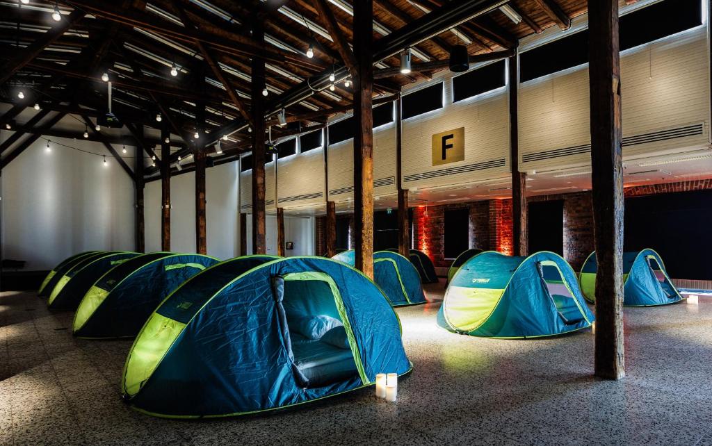 Un groupe de tentes est installé dans un bâtiment dans l'établissement Indoor Camping Helsinki, à Helsinki