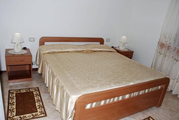 1 dormitorio con 1 cama con 2 mesitas de noche y 2 lámparas en Bed And Breakfast Eden Green, en Alghero