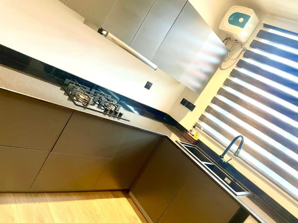 a kitchen with a sink and a window with blinds at Deserene apartment in Accra