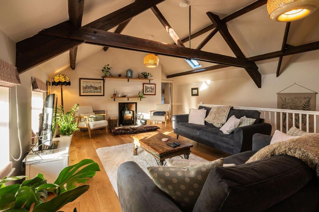 a living room with a couch and a table at Stable Cottage in Teffont Magna