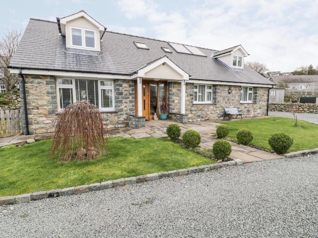 a stone house with a gravel driveway at Ty Ni in Dyffryn