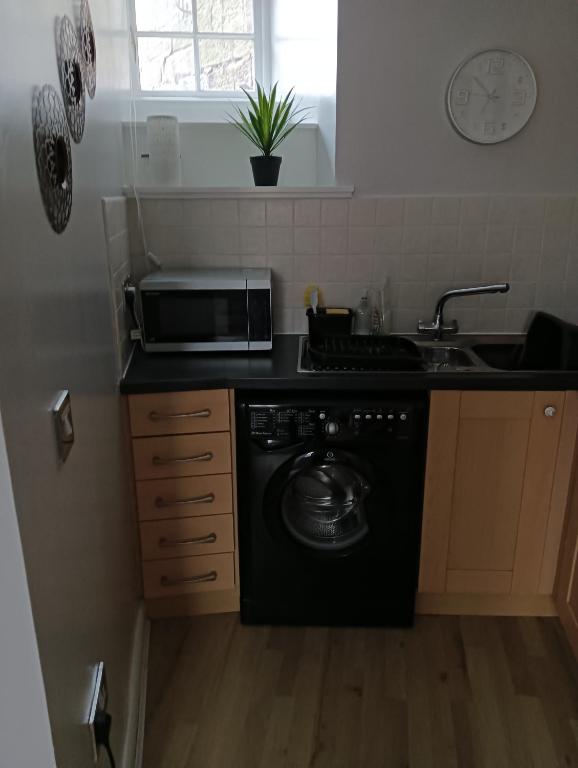 een keuken met een zwarte vaatwasser en een wastafel bij Berwick upon Tweed flat in Berwick-Upon-Tweed