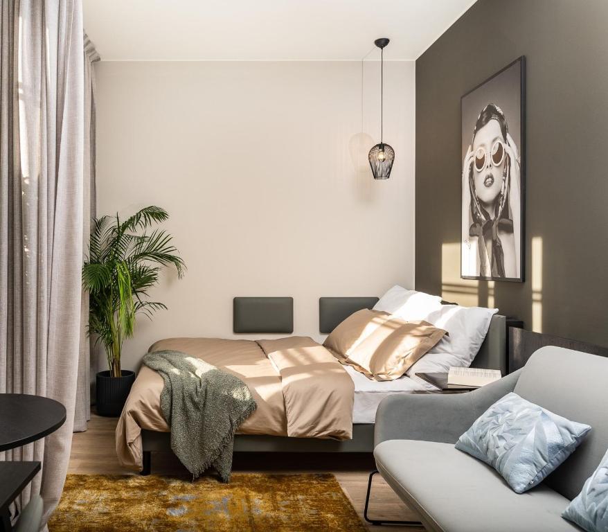 a bedroom with a bed and a couch at MILESTONE Krakow Center Urban Living in Krakow