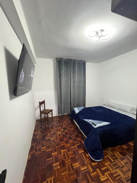 a bedroom with a bed and a tv and a chair at alojamiento A&A in Vigo