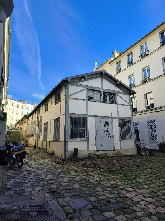 un bâtiment blanc dans une rue à côté de certains bâtiments dans l'établissement 30m2 in the heart of Paris, à Paris
