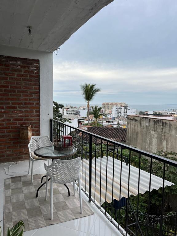 um pátio com uma mesa e cadeiras numa varanda em Casa Estrella em Puerto Vallarta