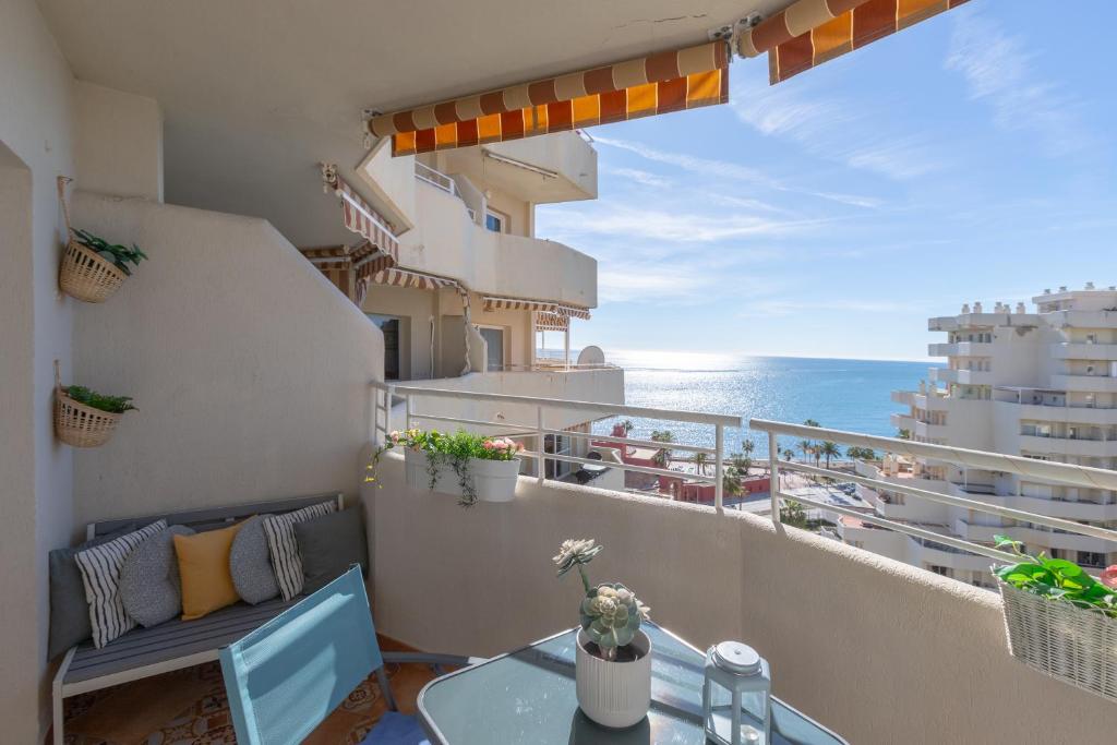 einen Balkon mit einem Tisch, Stühlen und Meerblick in der Unterkunft Apartamento costa del Sol in Benalmádena