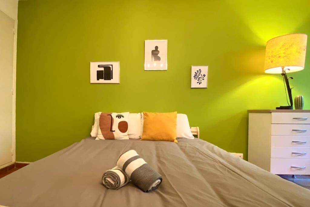- une chambre dotée d'un lit avec un mur vert dans l'établissement Studio de la gare, à Aix-en-Provence