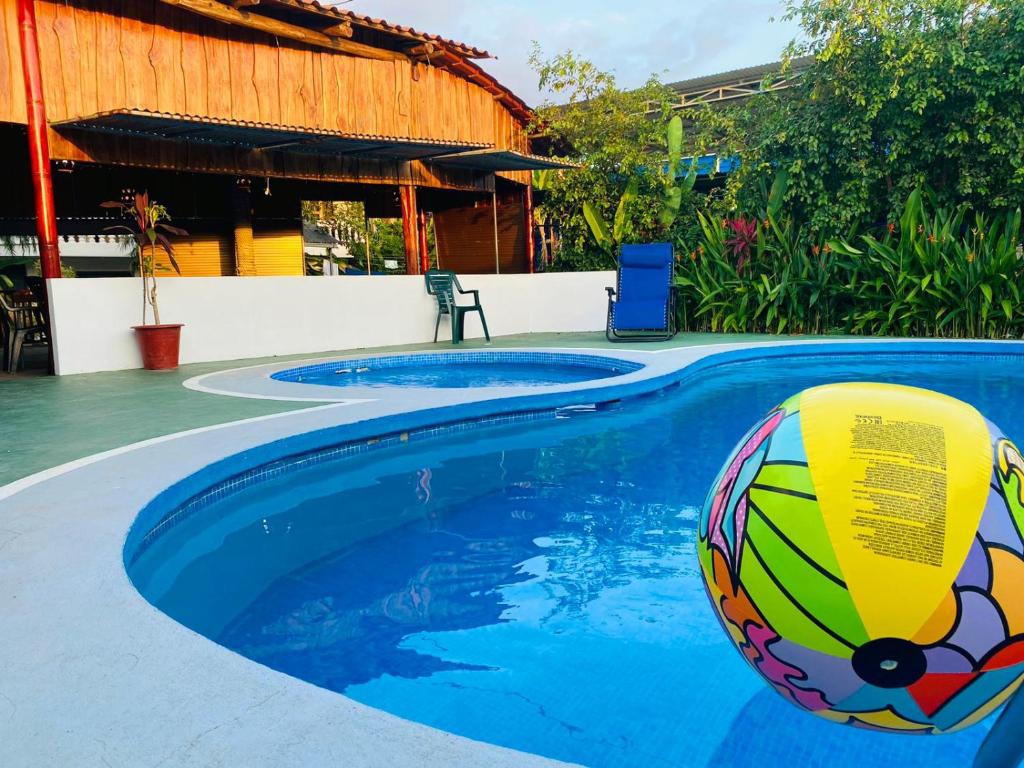 a pool with a beach ball in the water at HOTEL QUEPOS PARAISO i in Quepos