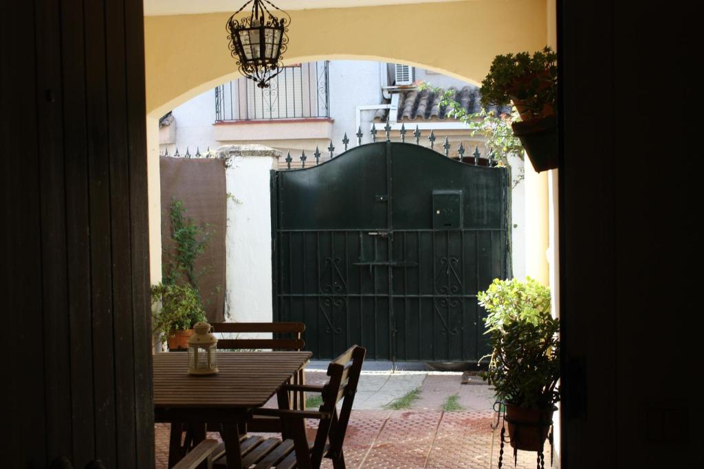 ヘレス・デ・ラ・フロンテーラにあるVilla Jardínの黒い門、テーブルと椅子付きのパティオ