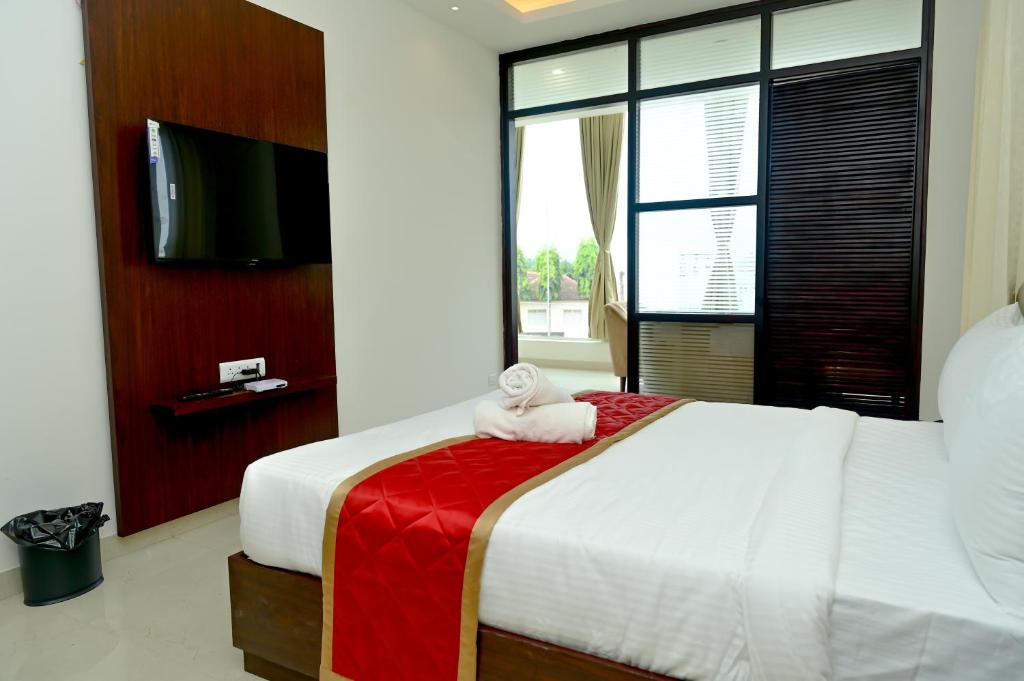 a hotel room with a bed with a towel on it at The Mallika Sapphire in Chikmagalūr