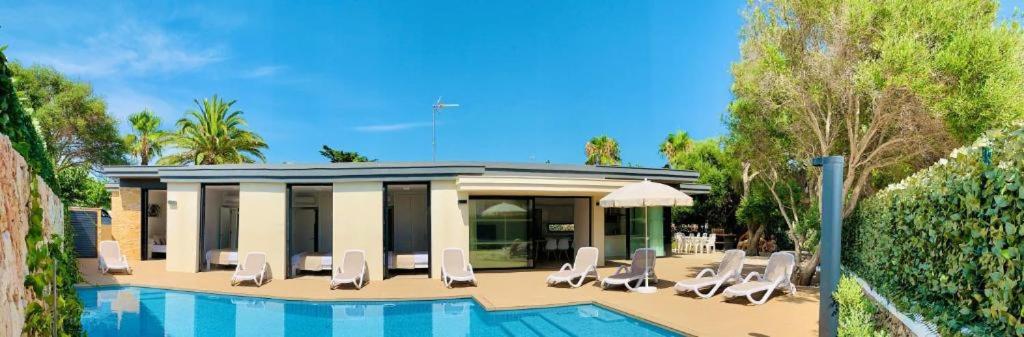 a group of lounge chairs and a swimming pool at Villa SONIA in Cala en Blanes