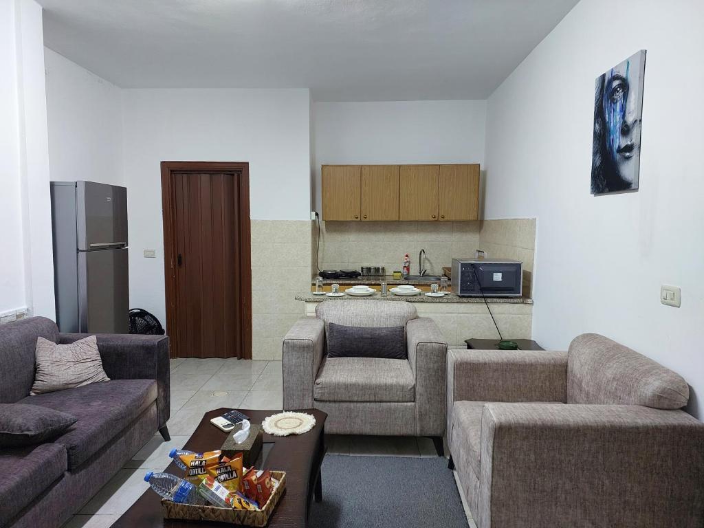 a living room with two couches and a kitchen at Cozy Home 2 in Amman