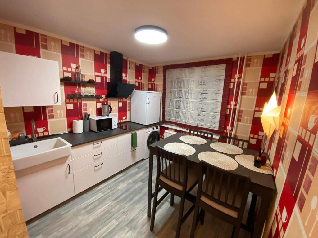 een keuken met een tafel en stoelen. bij Vieno kambario apartamentai 1 aukšte in Mažeikiai