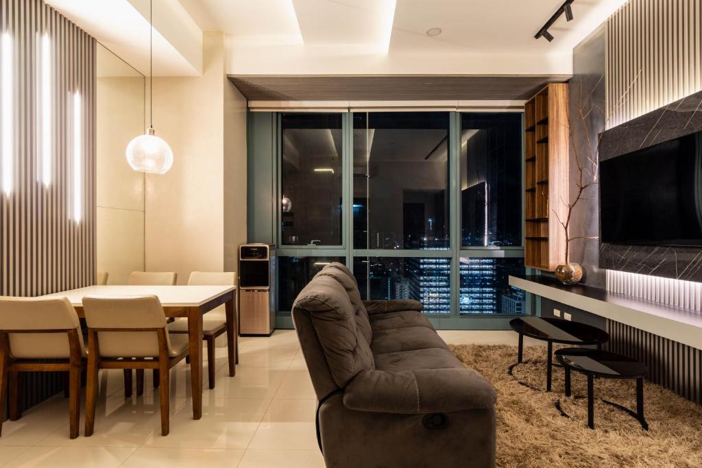 een woonkamer met een bank en een tafel met stoelen bij Luxury 2BR Gem in One Uptown bgc in Manilla