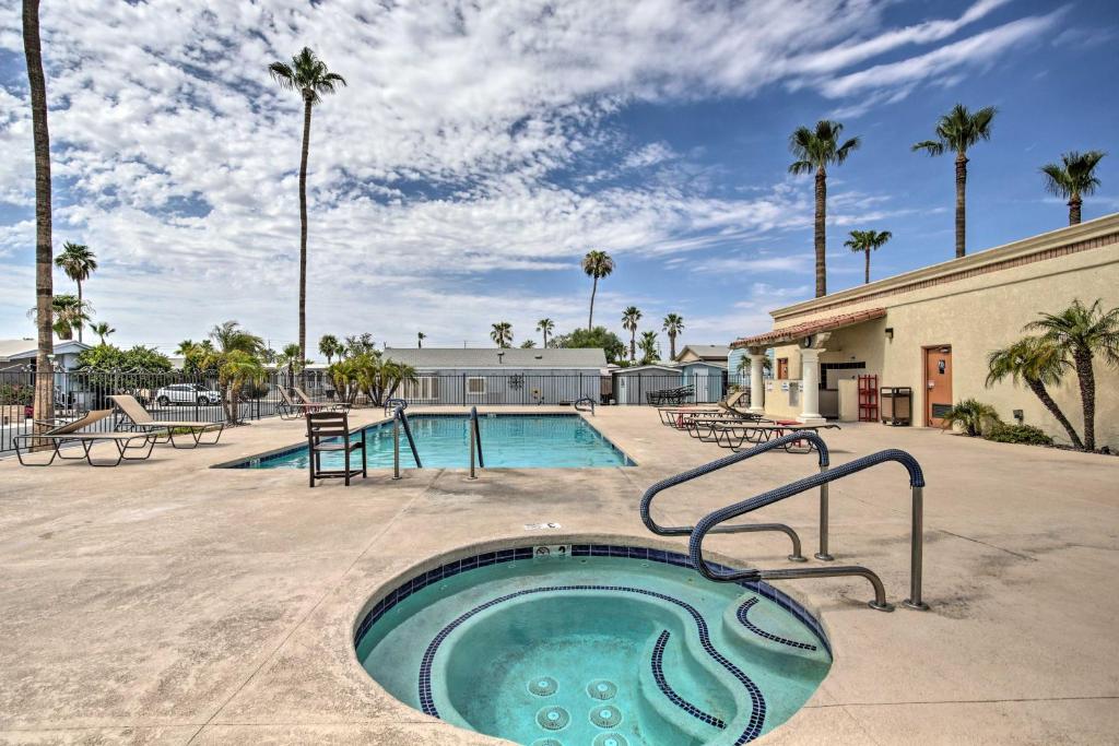 a hot tub in the middle of a pool with palm trees at Yuma Home with Fire Pit and Outdoor Community Pool! in Yuma
