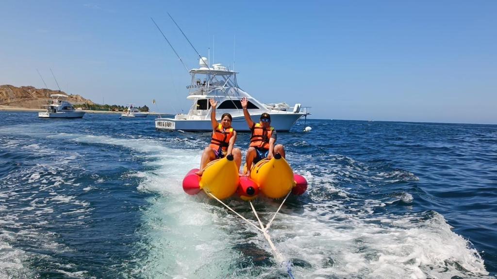 tres personas en una balsa en el agua con un barco en Las Fragatas Casa Hotel en Canoas de Punta Sal