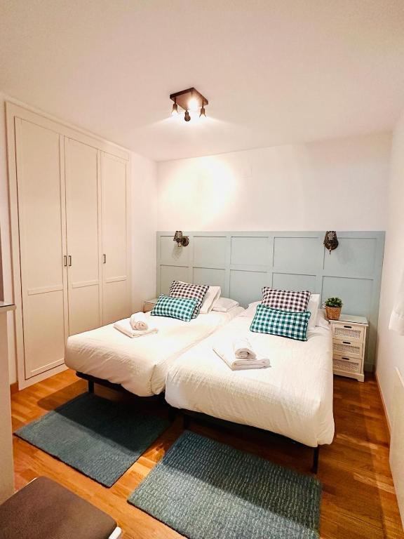 two twin beds in a room with wooden floors at Apartamento La Larri in Bielsa