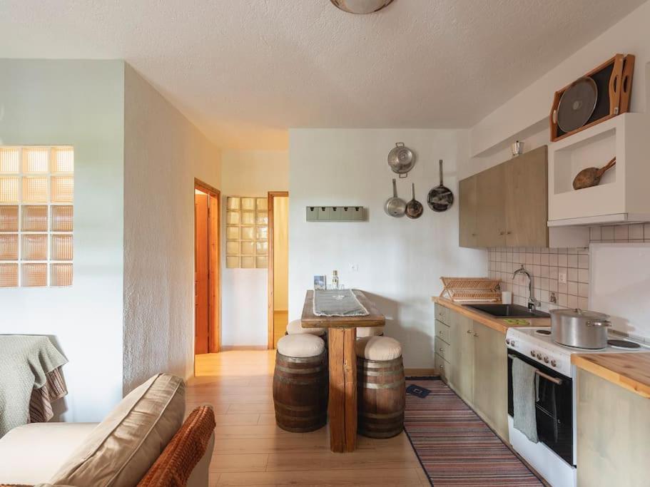 eine Küche mit einem Sofa und einem Tisch in einem Zimmer in der Unterkunft Traditional cosy chalet in Livadi in Kalívia