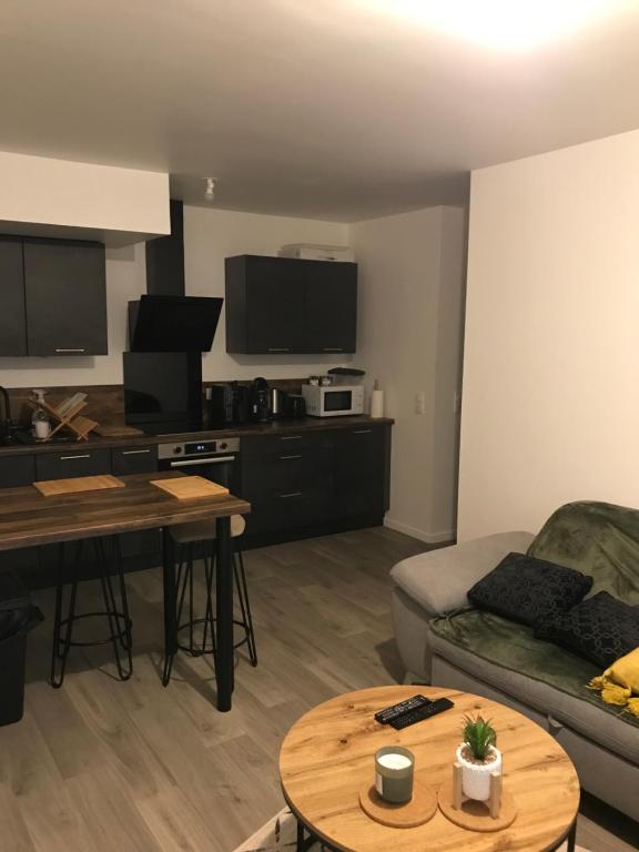 een woonkamer met een bank en een tafel bij Élégant Appartement proche Commodités - Parfait pour Jeux Olympiques 2024 in Maurepas