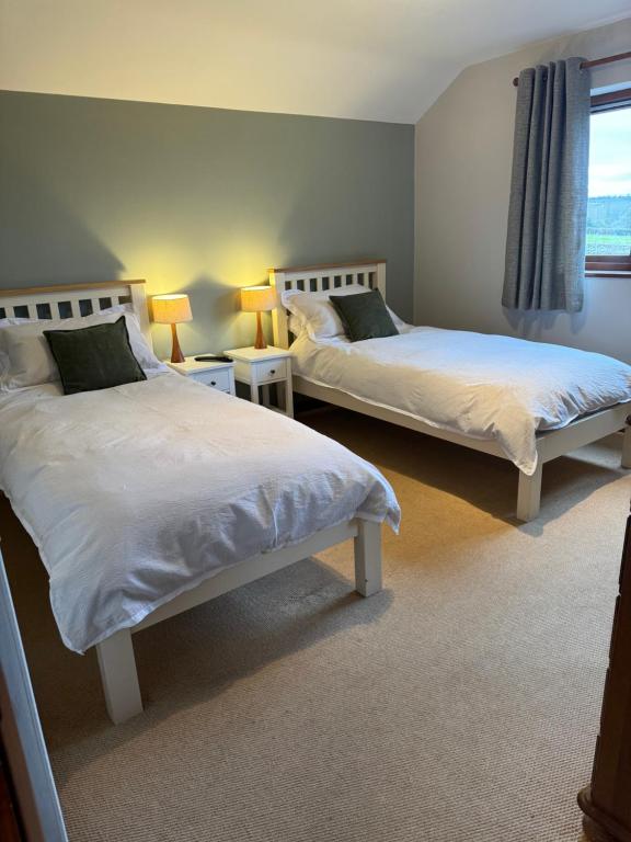 a bedroom with two beds and a window at Self Check-In Rooms at The Three Horseshoes Inn in Bromyard