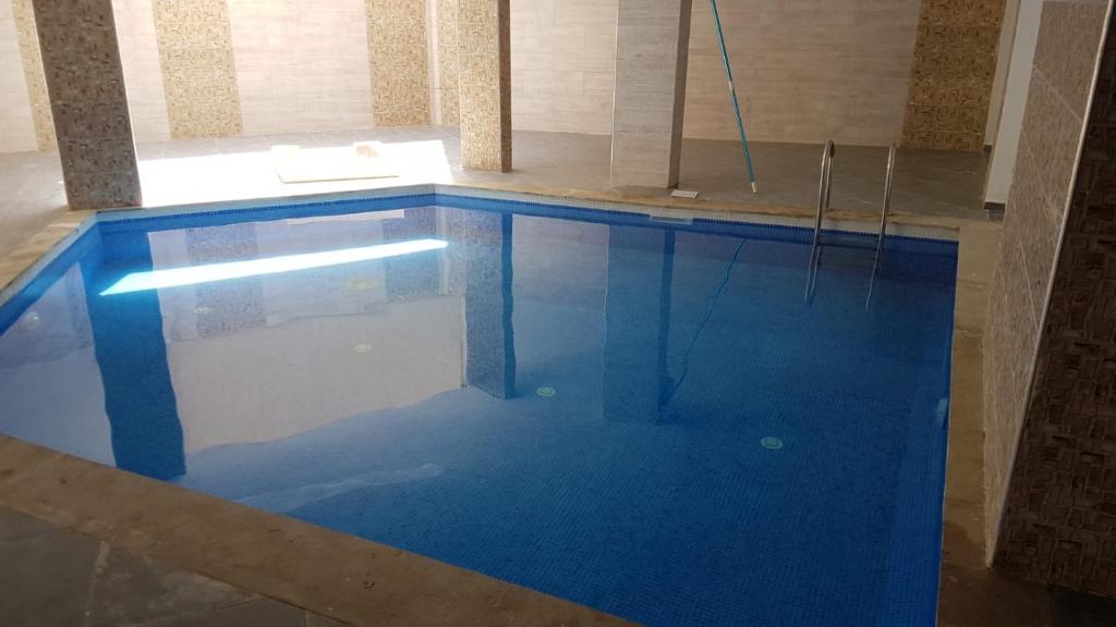 - une piscine d'eau bleue dans une chambre dans l'établissement Ibtissam home, à Kenitra