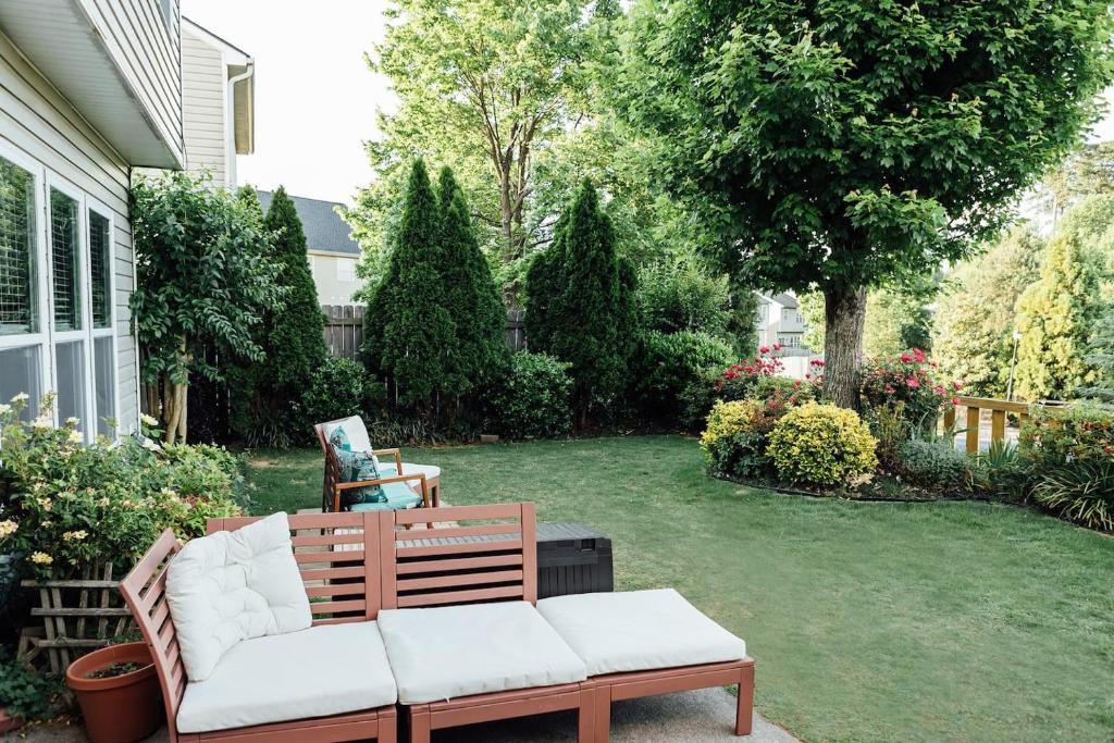a patio with a bench and a yard with trees at Entire 4br Private Home I-85 Access Family in Duluth