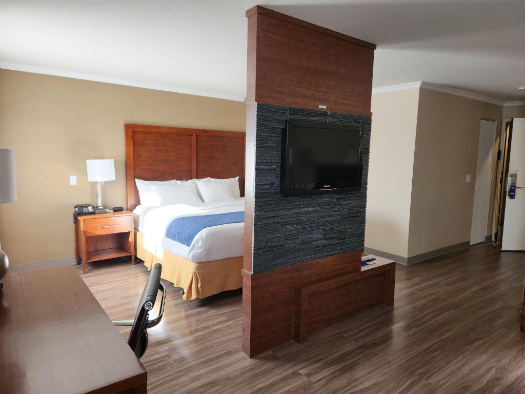 a hotel room with a bed and a flat screen tv at Comfort Inn in Saint-Georges