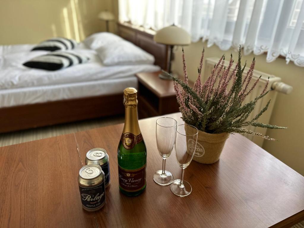 dos botellas y vasos en una mesa en un dormitorio en GLORIETTA Apartments & SPA, en Iwonicz-Zdrój