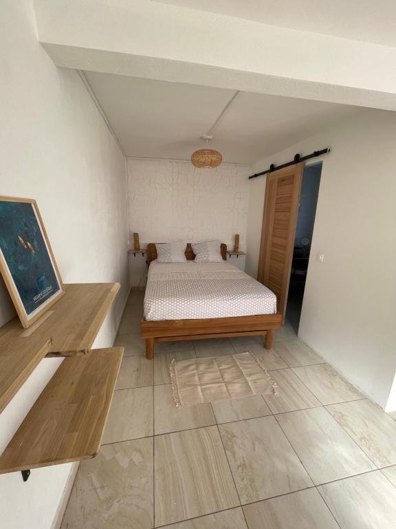 ein kleines Schlafzimmer mit einem Bett in einem Zimmer in der Unterkunft Tropic Valley Lodge in Vieux-Habitants