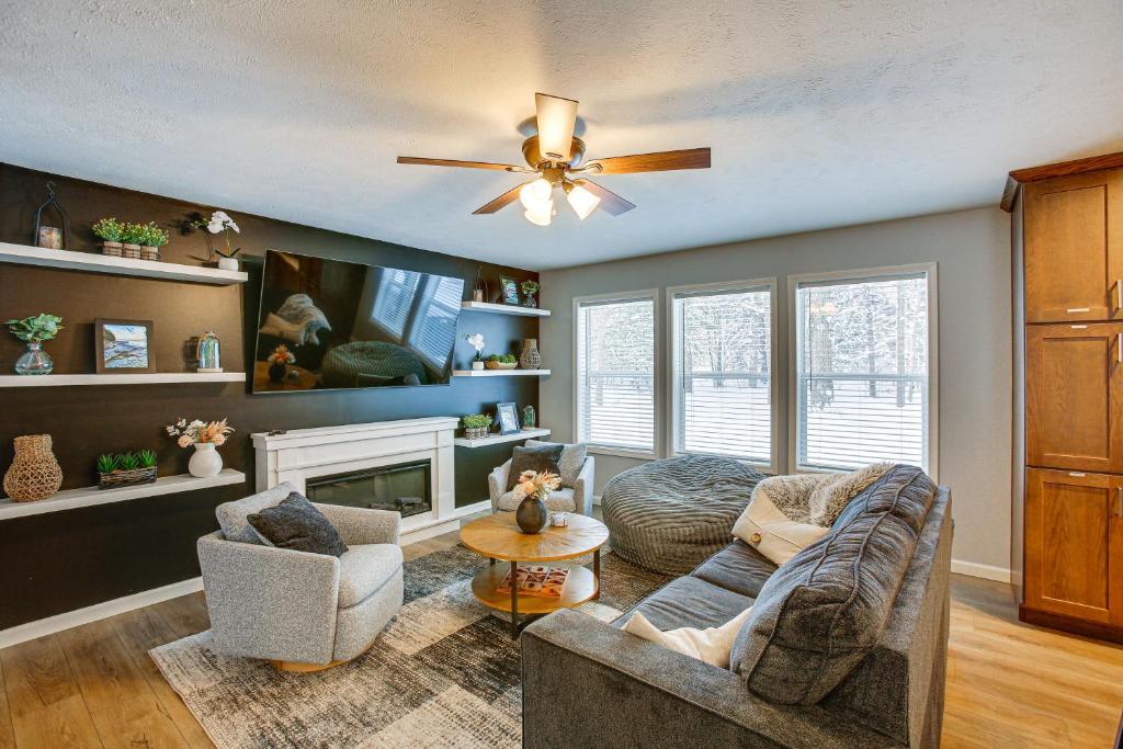 a living room with a couch and a ceiling fan at Wellston Home with Private Hot Tub and Fire Pit! in Irons