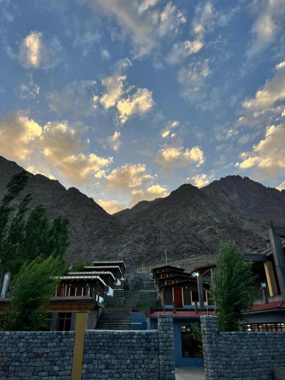 a group of houses with mountains in the background at Ashina Eco Resort in Kargil
